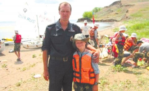 Участковый Д. Борзов со спасенным ребенком